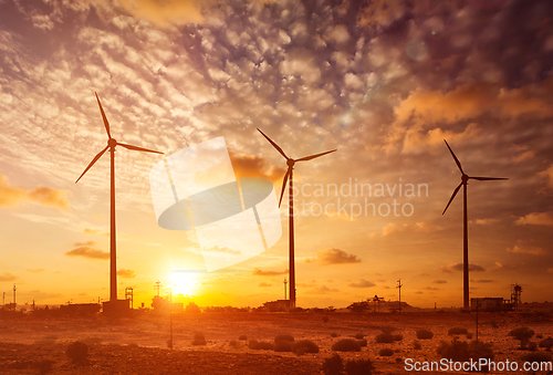 Image of Wind generator turbines sihouettes on sunset