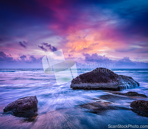 Image of Waves and rocks on beach of sunset