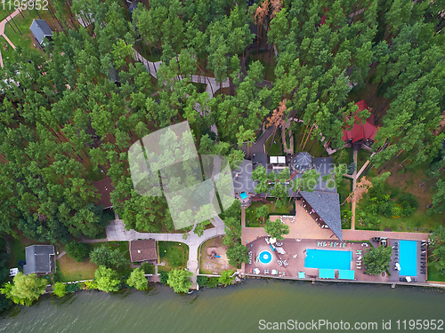 Image of Aerial view of luxury house garden with swimming pool surrounded by trees.