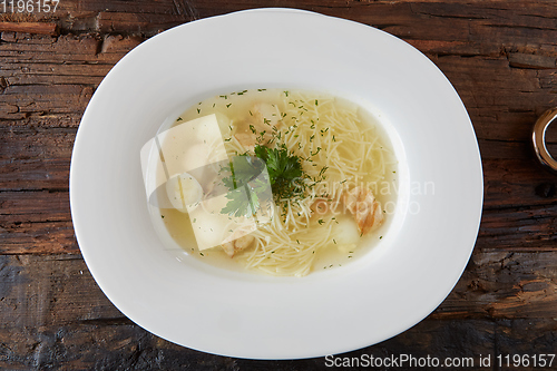 Image of Chicken soup with noodles and vegetables in white bowl