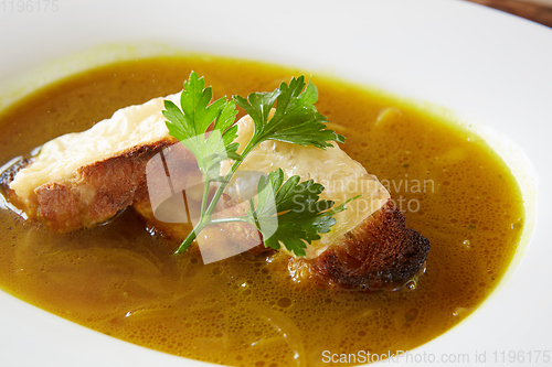 Image of Onion soup in the ceramic pot. Shallow dof.