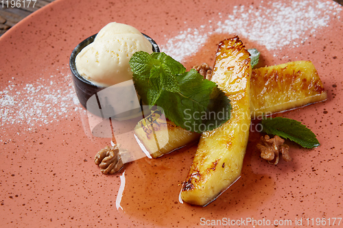 Image of Grilled pineapple with scoops of vanilla ice cream.