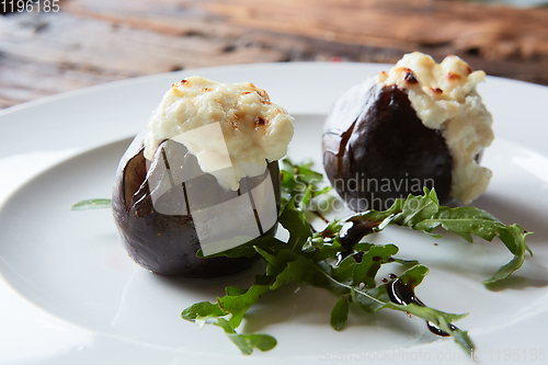 Image of baked figs with goat cheese on wooden table