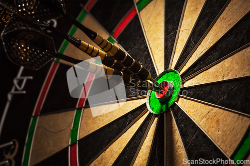 Image of Three darts in bull's eye close up