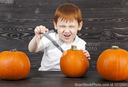 Image of redhead boy with red pumpkins