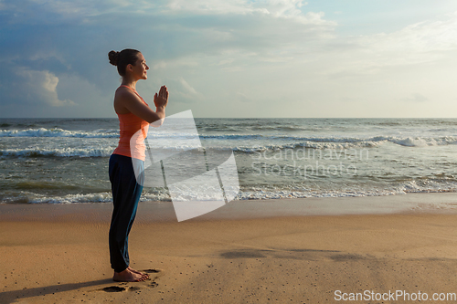 Image of Woman doing yoga on beach