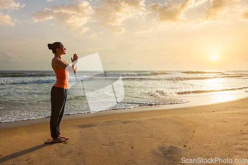 Image of Woman doing yoga on beach