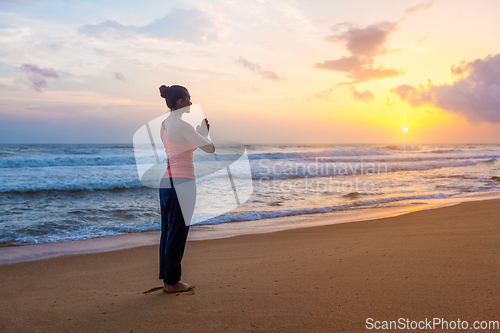 Image of Woman doing yoga on beach