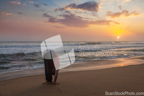 Image of Young sporty fit woman doing yoga Sun salutation Surya Namaskar