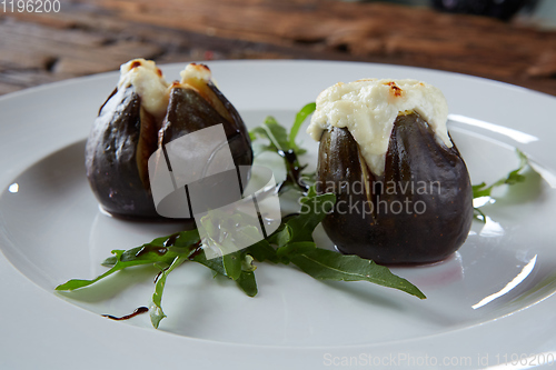 Image of baked figs with goat cheese on wooden table