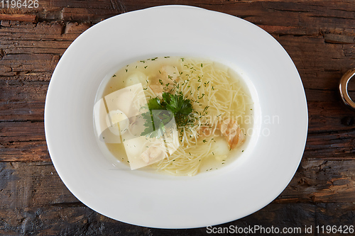 Image of Chicken soup with noodles and vegetables in white bowl