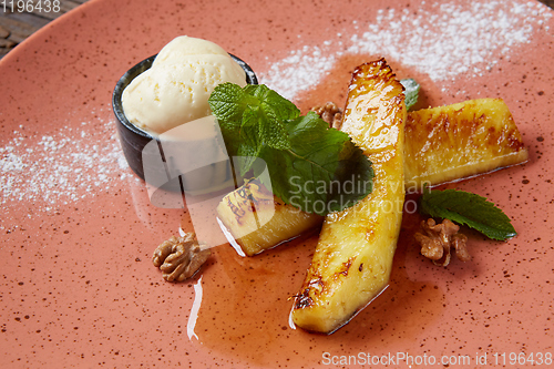 Image of Grilled pineapple with scoops of vanilla ice cream.