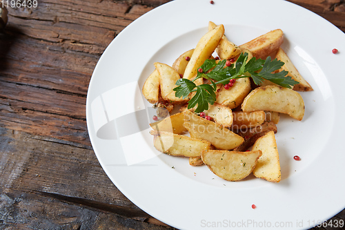 Image of Homemade roasted potato with parsley on rustic background.