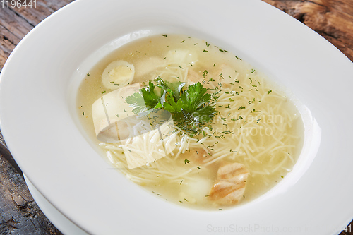 Image of Chicken soup with noodles and vegetables in white bowl