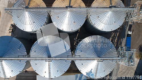 Image of Agricultural Silo. Storage and drying of grains, wheat, corn, soy, against the blue sky with clouds.