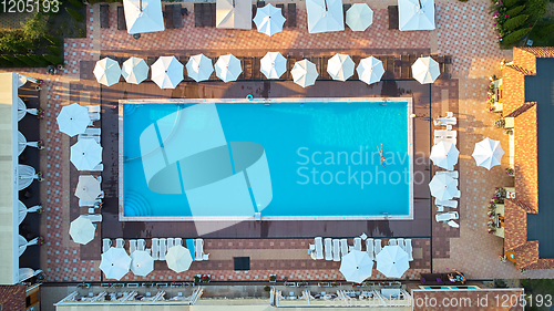 Image of Aerial view on people in swimming pool. Top view of people sunbathing pool.