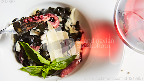 Image of Pasta with black cuttlefish ink, octopuses and parmesan.