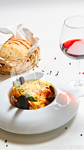 Image of The cooked mussels and pasta with wine glass.