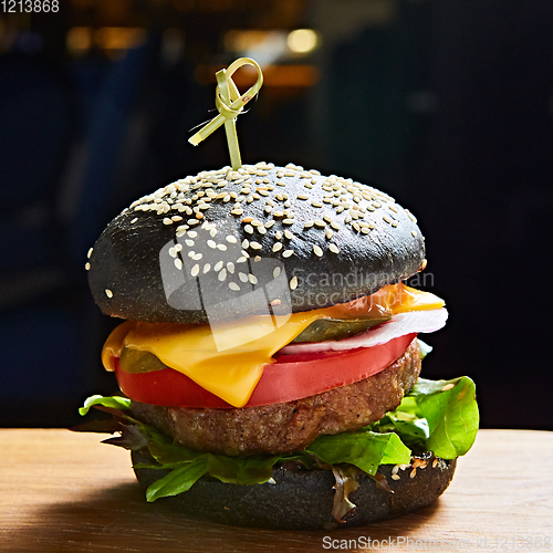 Image of Japanese Black Burger with Cheese. Cheeseburger from Japan with black bun on dark background.