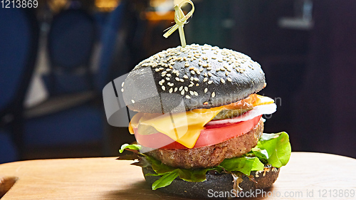 Image of Japanese Black Burger with Cheese. Cheeseburger from Japan with black bun on dark background.