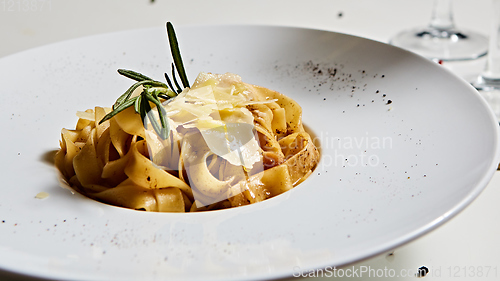 Image of Close-up italian pasta plate with grated parmesan cheese and basil leaf