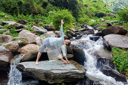 Image of Woman doing Ashtanga Vinyasa yoga asana outdoors