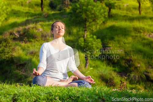 Image of Young sporty fit woman in yoga Lotus pose oudoors