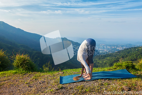 Image of Young sporty fit woman doing yoga Sun salutation Surya Namaskar