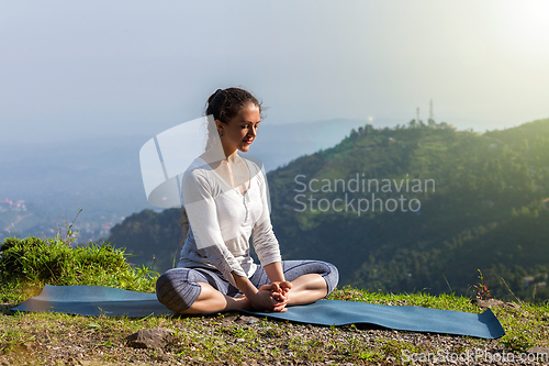 Image of Woman practice yoga asana Baddha Konasana outdoors