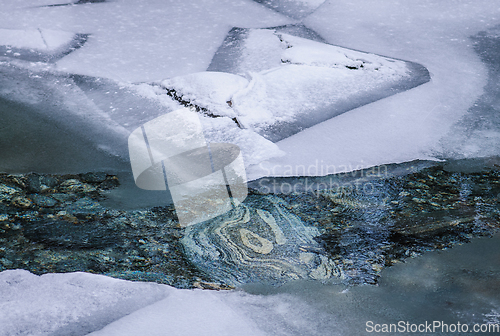 Image of frozen river with rocks in winter