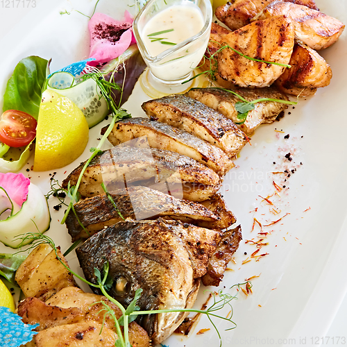 Image of The fried fish on plate with vegetables. Shallow dof.