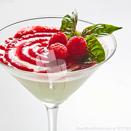 Image of Delicious Italian dessert Panna Cotta with raspberry in small transparent glass