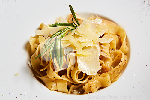 Image of Close-up italian pasta plate with grated parmesan cheese and basil leaf