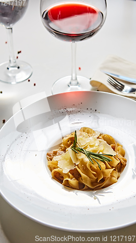 Image of Close-up italian pasta plate with grated parmesan cheese and basil leaf