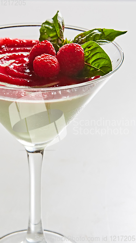 Image of Delicious Italian dessert Panna Cotta with raspberry in small transparent glass