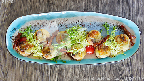 Image of Fried scallops with butter lemon spicy sauce served with green salad. Top view, copy space.