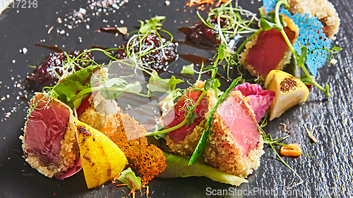 Image of Close up of rare seared Ahi tuna slices with fresh vegetable salad on a plate.