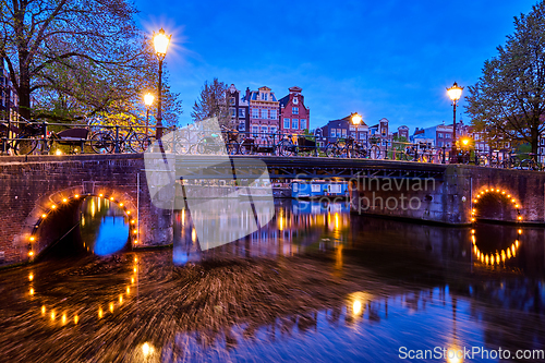 Image of Amterdam canal, bridge and medieval houses in the evening