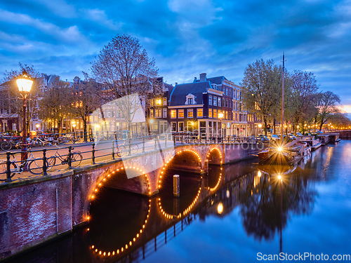 Image of Amterdam canal, bridge and medieval houses in the evening