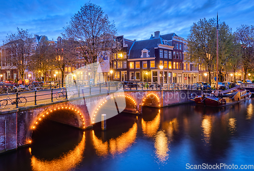 Image of Amterdam canal, bridge and medieval houses in the evening