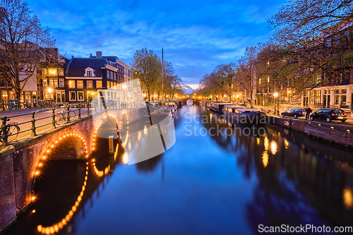 Image of Amterdam canal, bridge and medieval houses in the evening