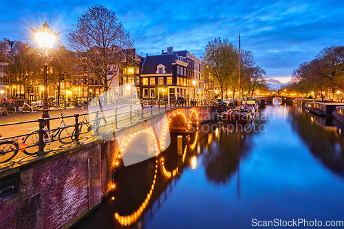 Image of Amterdam canal, bridge and medieval houses in the evening