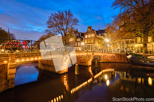 Image of Amterdam canal, bridge and medieval houses in the evening