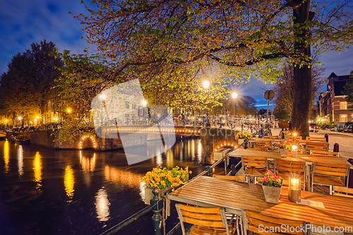 Image of Amterdam cafe tables, canal, bridge and medieval houses in the e