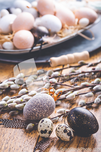 Image of Easter eggs with pussy-willow branch on wooden kitchen table