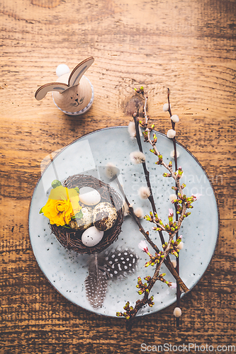 Image of Easter table setting with spring flowers and cutlery on wooden table