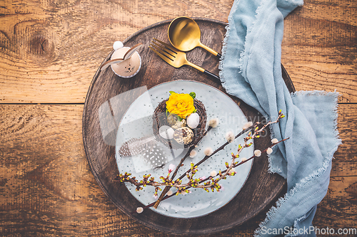 Image of Easter table setting with spring flowers and cutlery on wooden table