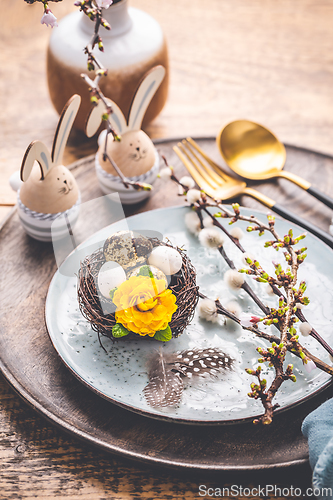 Image of Easter table setting with spring flowers and cutlery on wooden table
