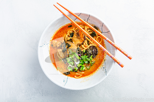 Image of Thai red curry noodle soup with shiitake,  coconut milk and onions