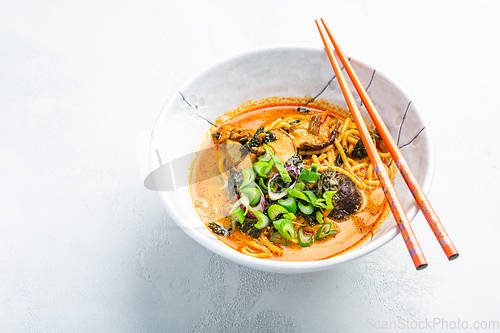 Image of Thai red curry noodle soup with shiitake,  coconut milk and onions